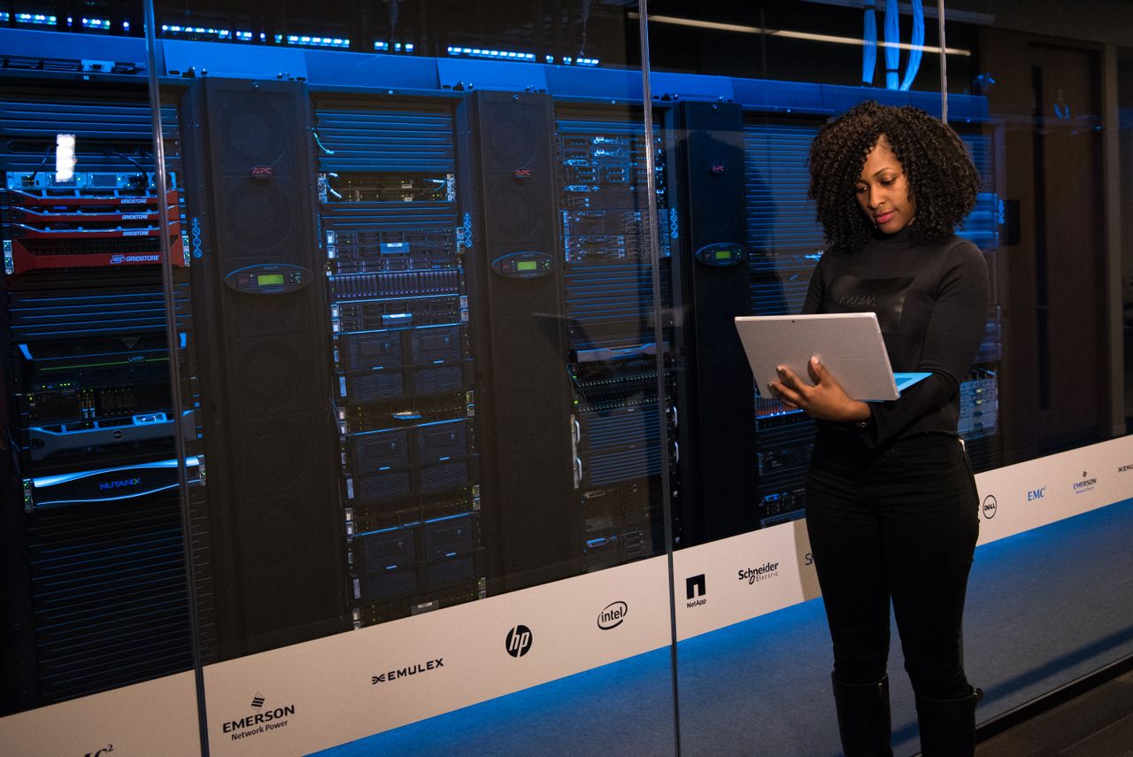 The Art of Drawing Readers In: Your attractive post title goes here A female engineer using a laptop while monitoring data servers in a modern server room.