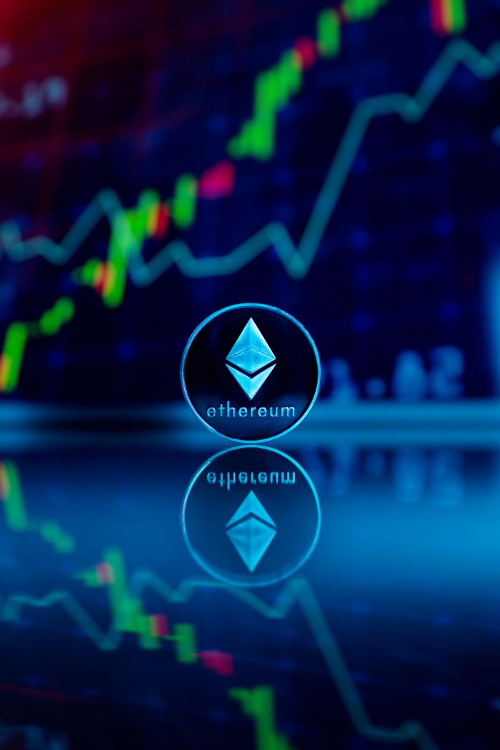 home-hero Ethereum coin reflecting with financial graph in the background, symbolizing digital currency trading.